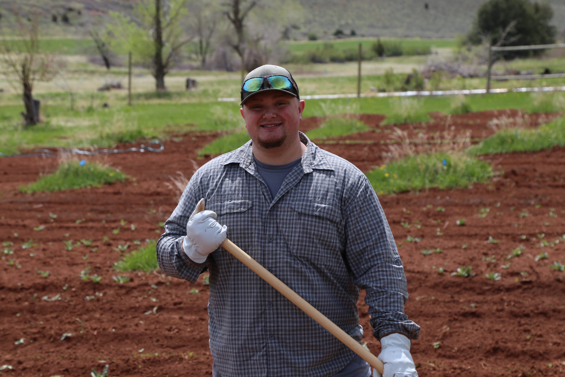 A student looking at the camera with a smile while he farms
