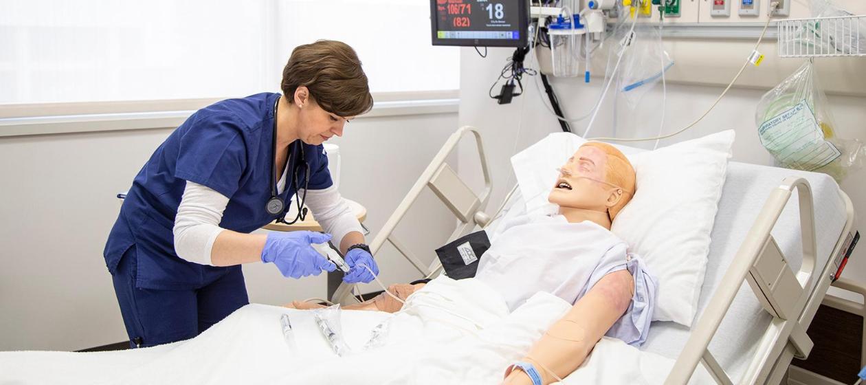A nursing student working the simulation lab.