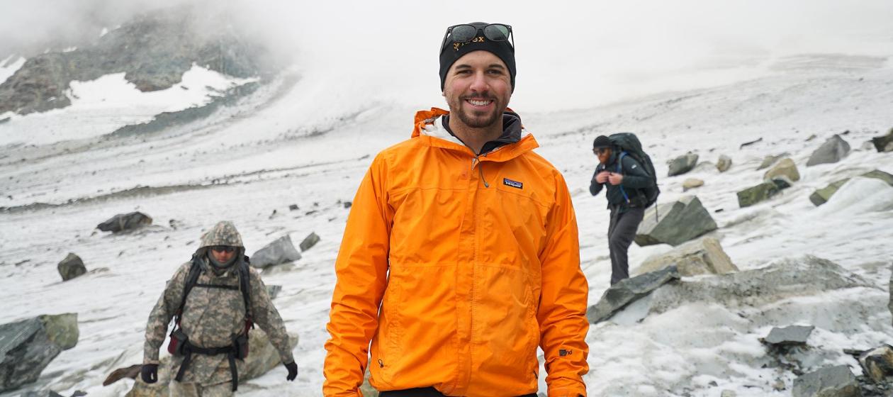 A student in an orange coat does research on the Dinwoody Glacier. 