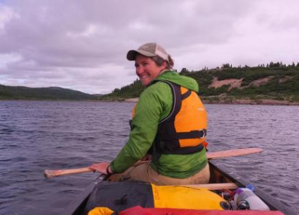 Jen Adams sits in a canoe on a lake
