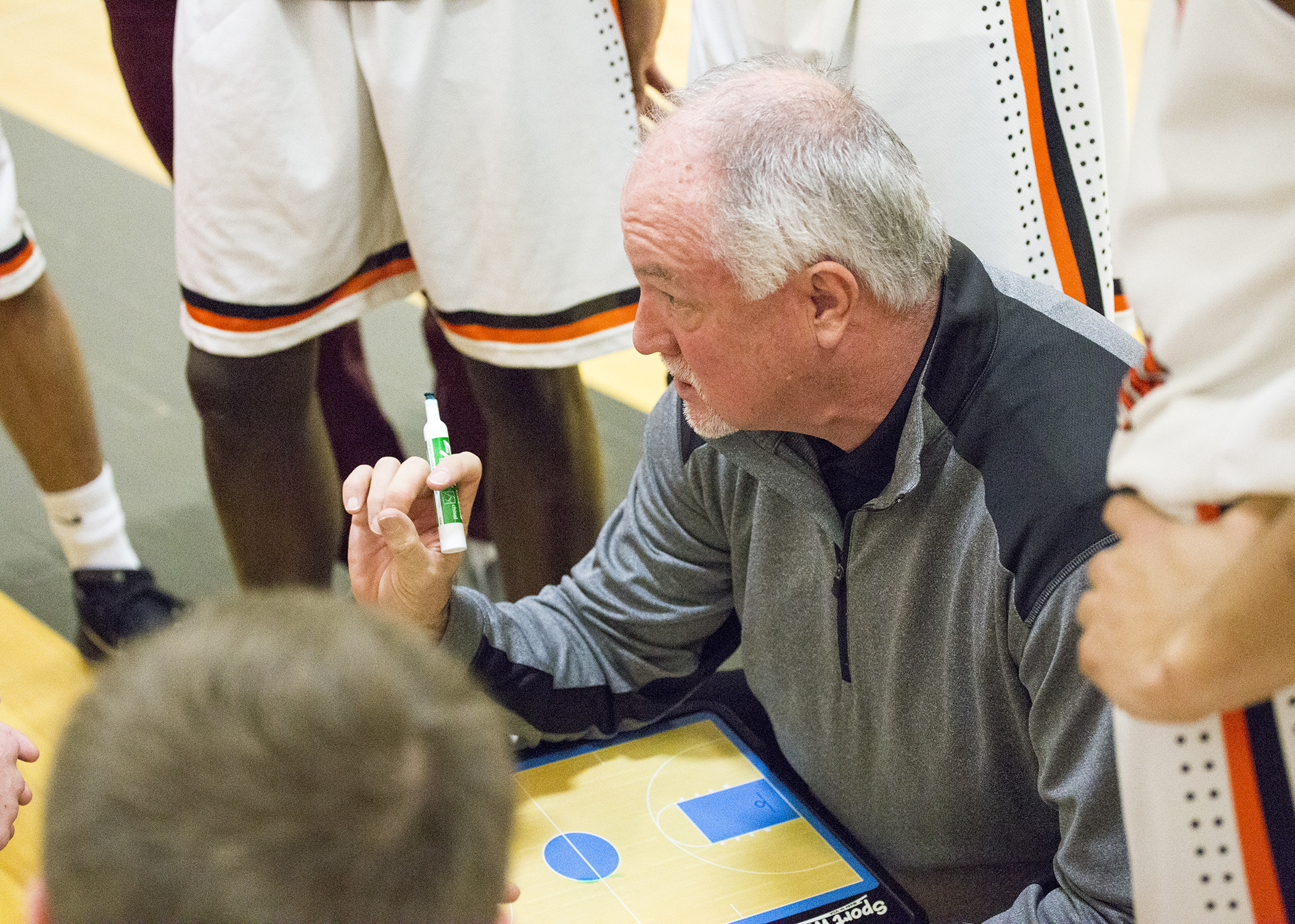 Coach Pat Rafferty showing a play to his basketball team
