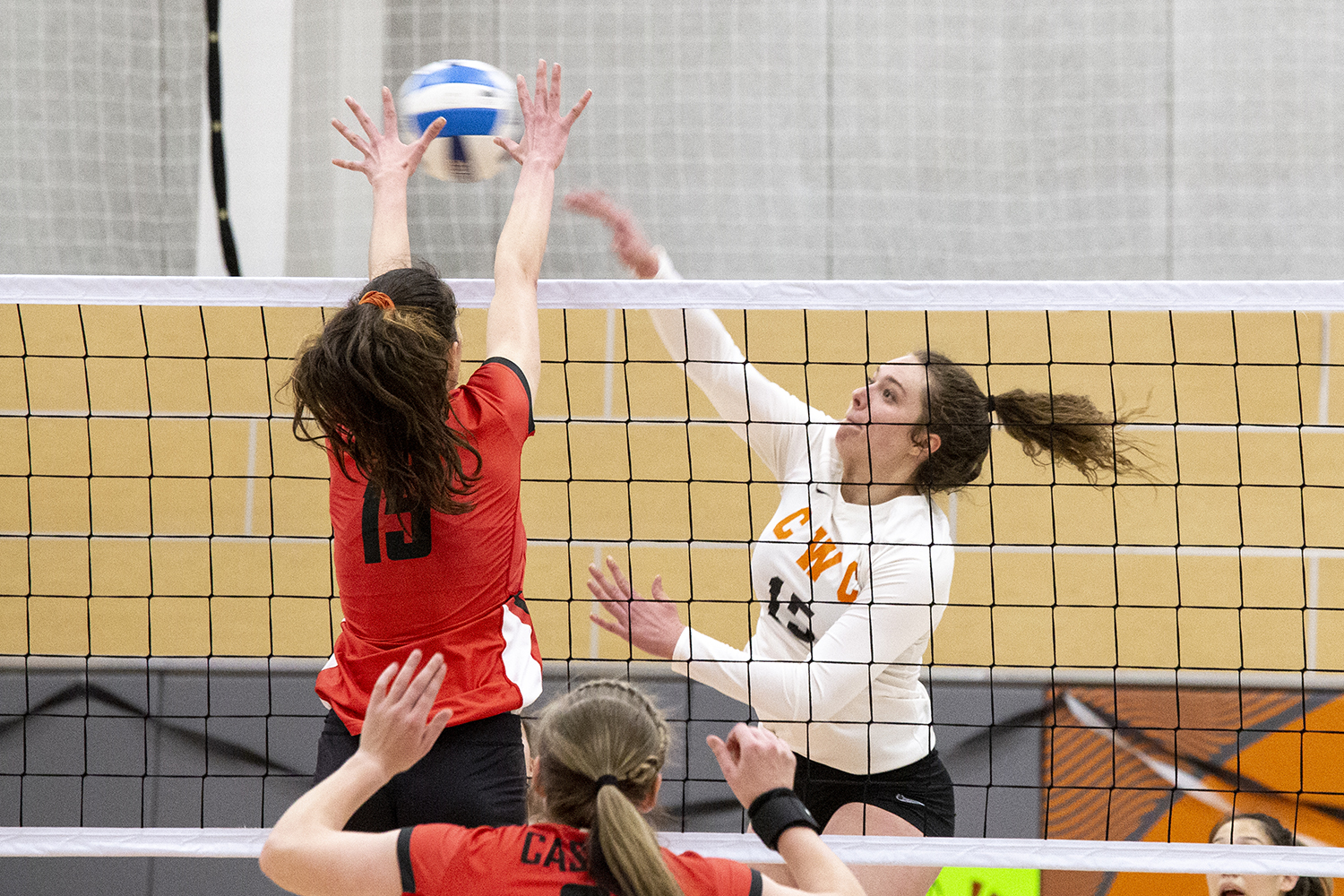 cwc volleyball player spikes the ball over the net