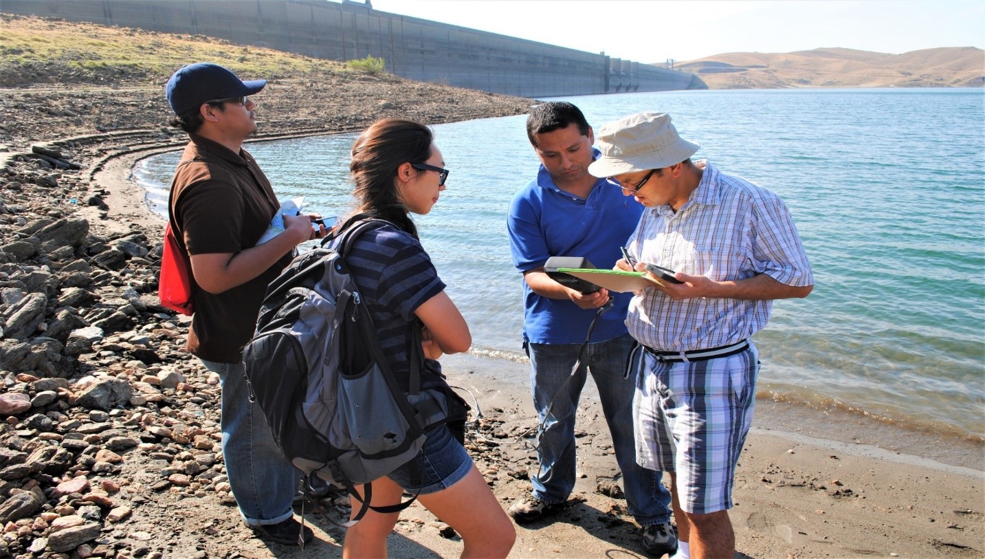 photo of CWC alumnus Mohan Dangi (in white hat) works with UCLA and Fresno State students to study water quality of Millerton Lake, California.