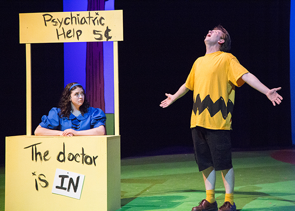 Actors playing Charlie Brown and Lucy at her psychiatry booth