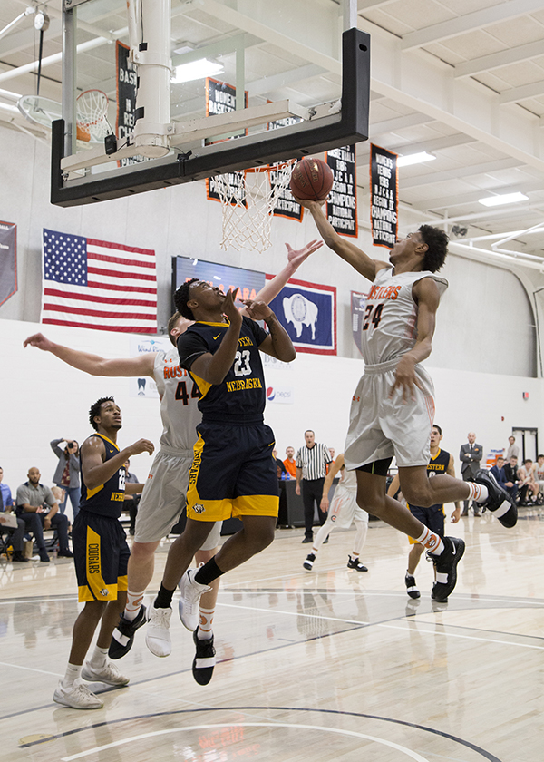 CWC men's basketball player going for a layup