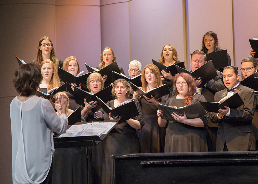 A choir sings in a performance on stage