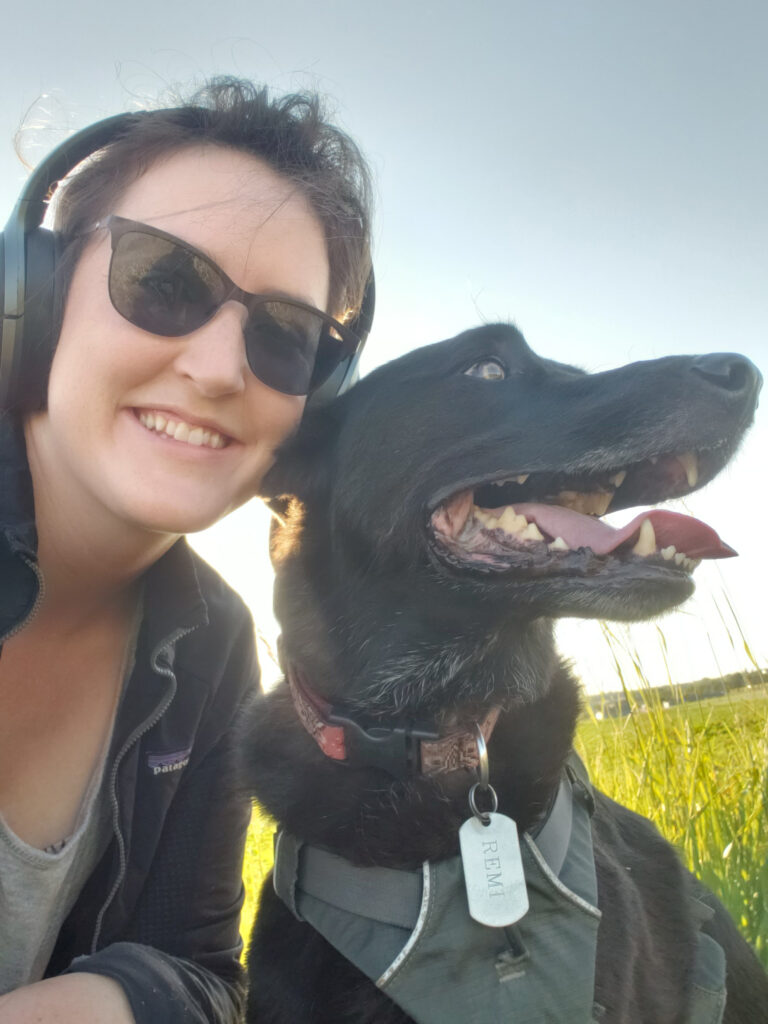 portrait of Caitlin Heryford with her black lab dog