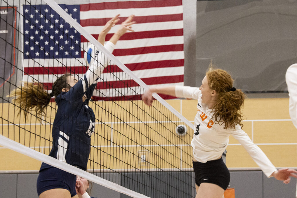 CWC volleyball player spikes the ball over the net