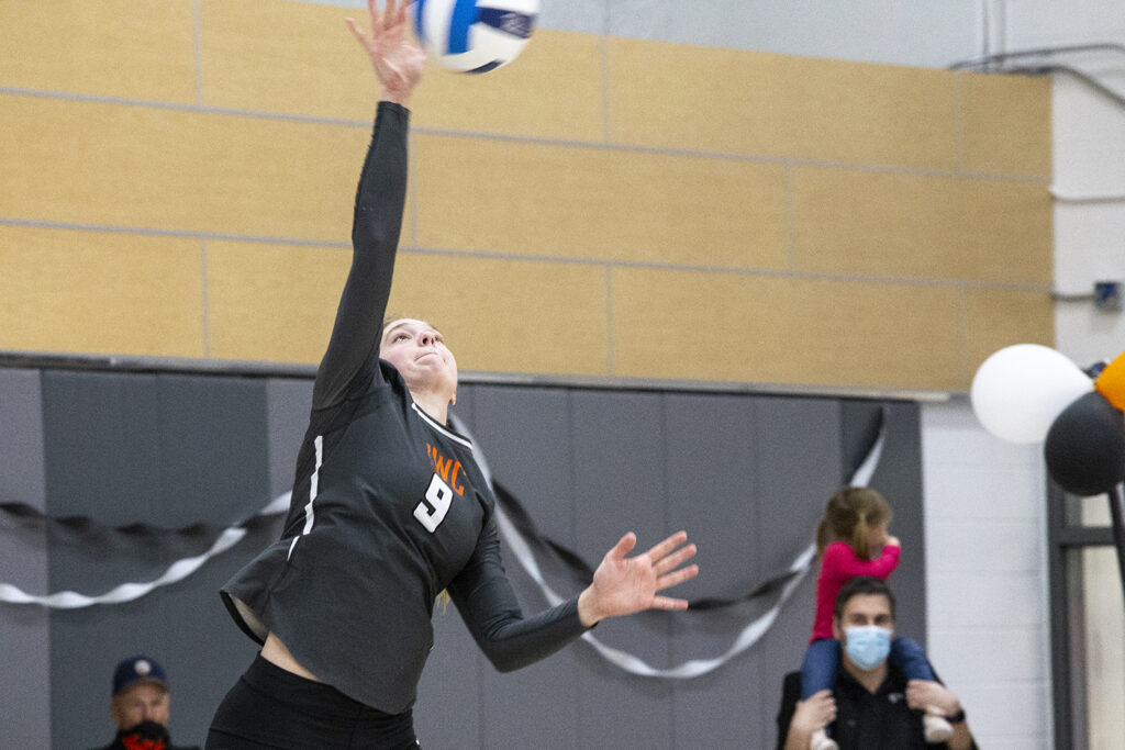 CWC volleyball player spikes the ball over the net