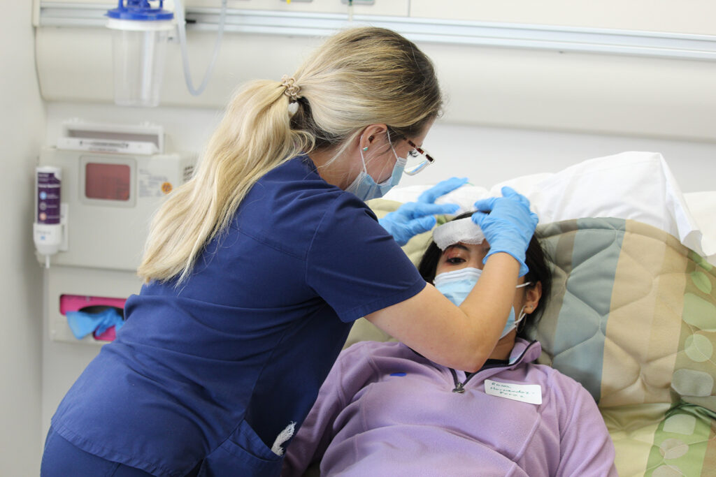 nursing student works on a patient with a mock injury