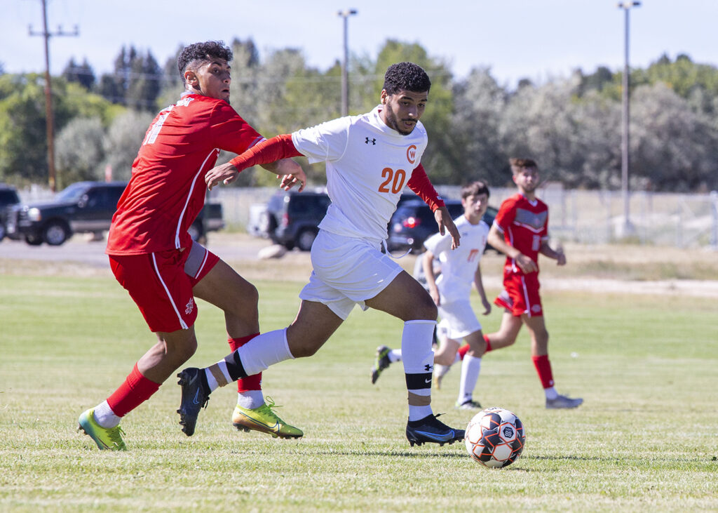 CWC soccer player kicks the ball away from the opposite team