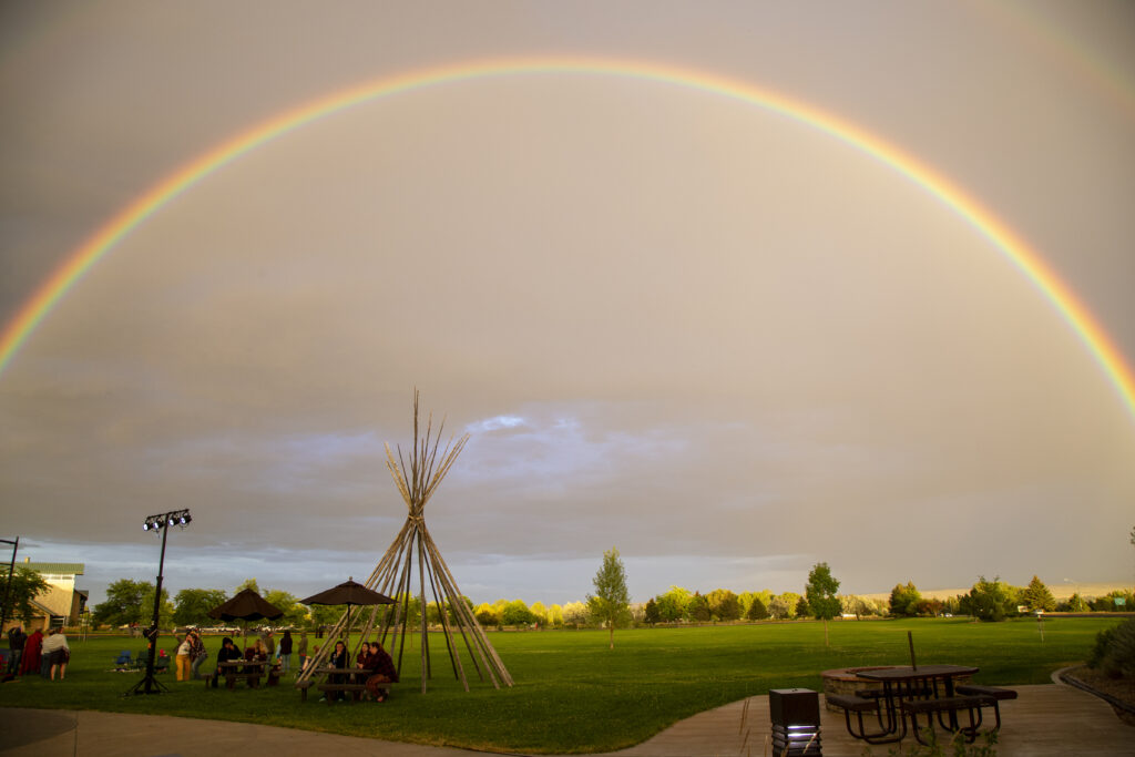 photo of teepee with a rainbow in the background