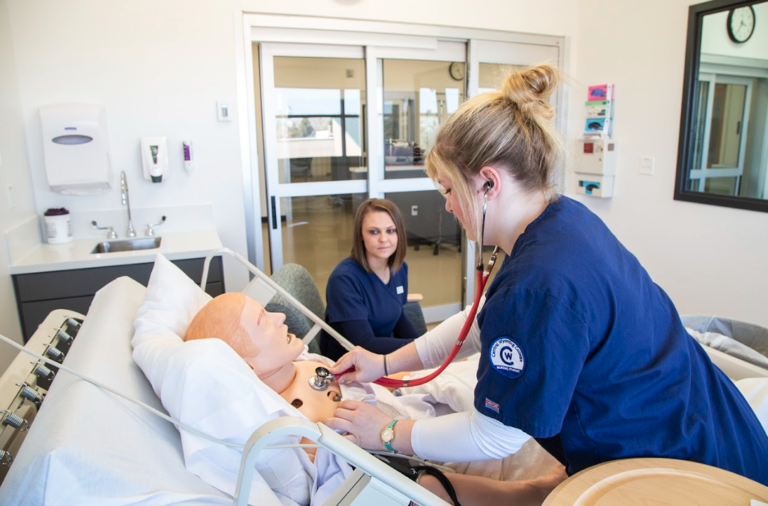 Two CWC Nursing Student practicing nursing on a faux patient