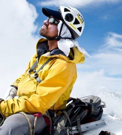 Darran Wells in his outdoor winter gear sitting in the snow.