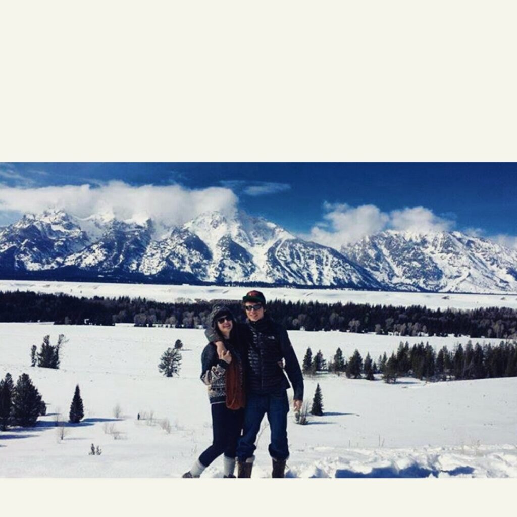 two students in the snow near the mountains