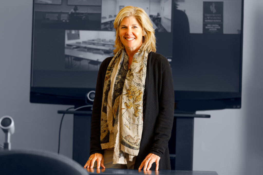 Sandy Hessler standing by a desk