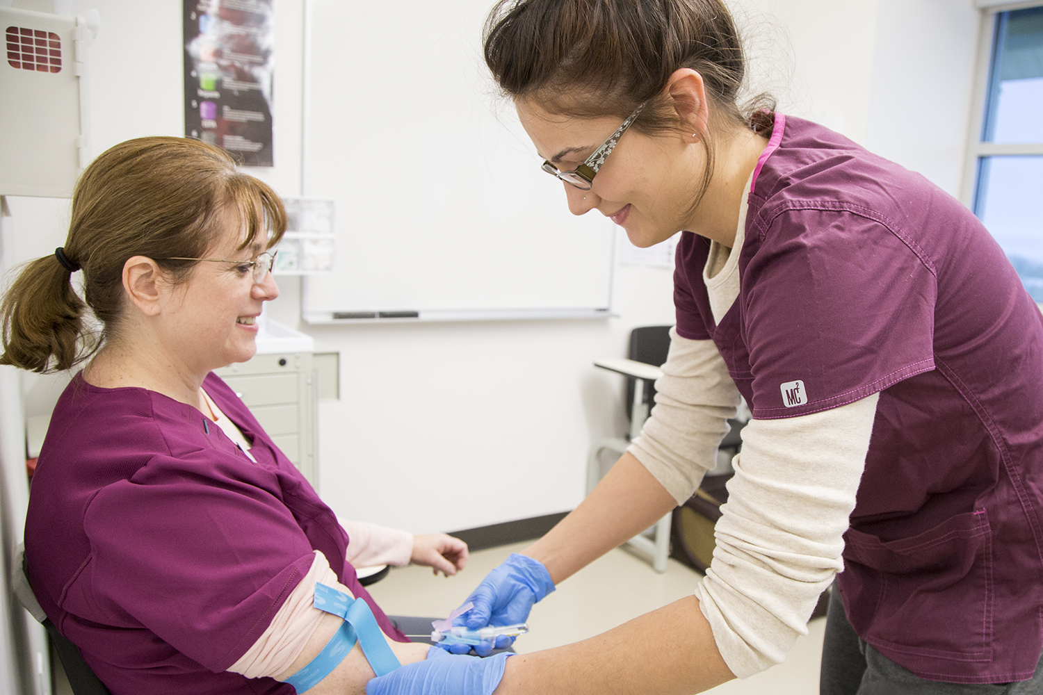 medical student prepares to draw blood from another medical student