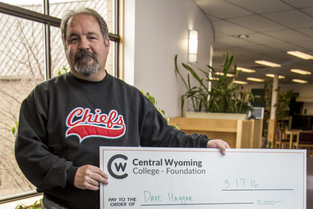 photo of the Rustler 400 winner, Dave Haggar holding a giant check of his winnings