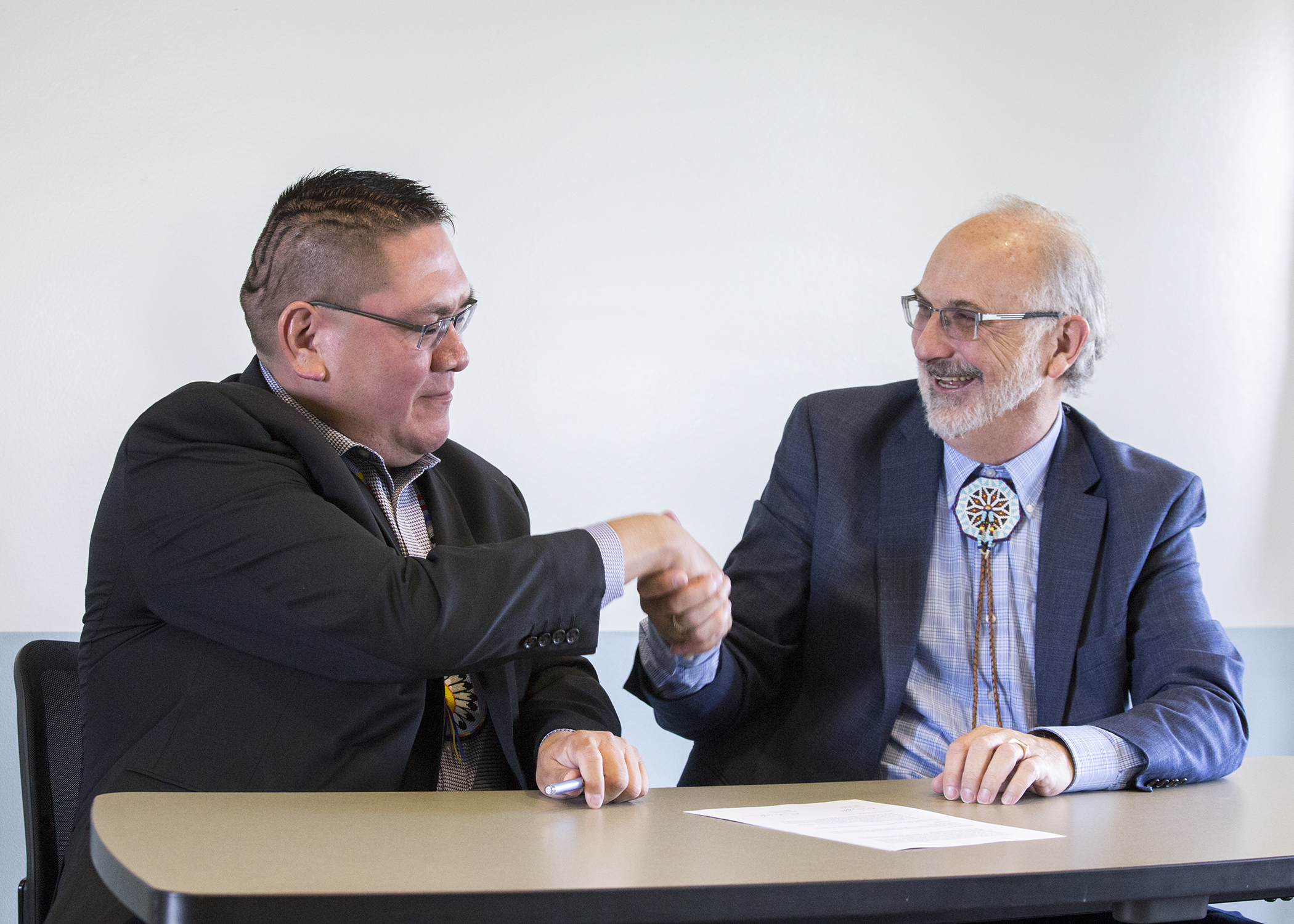 photo of Northern Arapaho Business Council chairman shakes hands with Central Wyoming College president.